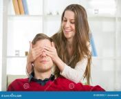 woman puts his hand over his eyes man to make him surprise men selective focus 50033852.jpg from wife surprise man