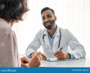 young cheerful indian doctor therapist white robe having appointment female patient sitting table filling medical form 228674368.jpg from indian doctor and patient 3x videos free download