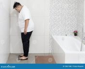 picture young fat man checking his weight standing scale shot bathroom young fat man checking his weight 139611686.jpg from fat bathrum na