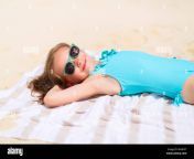 adorable little girl lying on a beach towel during summer vacation mnhpft.jpg from young cute bikini white towel comes out pool vacation travel summer activity young cute 133993773 jpg