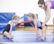 coach with two girls doing gymnastics exercise on floor 545876787 59b87d5e054ad9001126cd9a.jpg from gymnastics training flexible