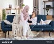 stock photo young muslim woman in hijab sitting at home on blue couch and enjoying time with her cute daughter 1941608608.jpg from saudi arabian suhagrat son mom blue film hindi sex xxx