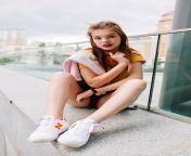 amazing dark haired girl white sneakers sitting stone parapet with overcast sky skyscrapers 197531 4550.jpg from school small nude photes
