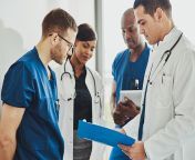 medical doctors and nurse practitioners discuss paperwork in a hallway.jpg from haspetel nurse with daktor
