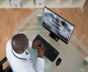 42190633 young african dentist analyzing x ray teeth on screen of computer at desk.jpg from 42190633 jpg