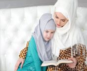 122694711 muslim mom in white hijab and traditional clothes is reading for her little daughter a book and.jpg from mom jilbob