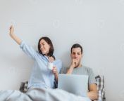 glad female stretches in bed drinks hot coffee and her husband works all night on laptop computer yawns as wants to sleep spend time together in bedroom isolated over white background photo.jpg from n8 time husband drink wife breast milk and wife give milk to husband long time video mp3hraddha kapoor