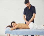 young woman is lying down when man doing massage of her back at spa photo.jpg from ladies massage for man