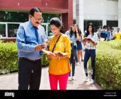 indian college teacher and girl student looking at mobile phone studying education learning in outside campus 2a7jj5r.jpg from indian college teacher