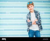 fashion portrait of caucasian blue eyed blonde hair 12 year old teenager boy dressed t shirt and checkered shirt with sunglasses posing on turquoise b 2c5pgkc.jpg from 12 old blonde tee