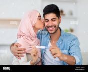 happy arab woman kissing her husband with positive pregnancy test at home muslim couple happy to find out about their future baby exchanging caresse 2ge67yj.jpg from arab hijab with her lover scandal mms