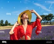 portrait of a woman playing with her straw hat in a lavender field she closes her eyes and smells the delicious scent of lavender flowers in the air 2gfa18c.jpg from plays with her delicious