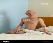 portrait of a bald asian man with no clothes except a white towel sitting on a bed in a room 2eaxk0c.jpg from no cloths