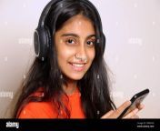 girl in the headphones lovely indian girl teenager 14 years old listens to music on headphones relaxes enjoys music lover since childhood 2fm8yeg.jpg from 14 yrars indian gi