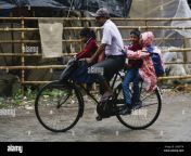father returns his children from school on a bicycle in a rainy day in barpeta road town at barpeta district of assam india on october 25 2019 photo by david talukdarnurphoto 2kb97tk.jpg from local borpeta rod