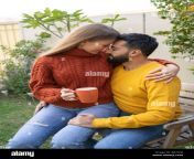 woman with coffee cup sitting on mans lap in garden 2j61n9j.jpg from lap in