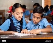 focus on girl kid helping his friend for studying at classroom concept of friendship education and learning 2j1x9ce.jpg from downloads indiyan shool techer milk boos