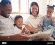 mixed race family reading a book together on the couch at home hispanic mother and father teaching their little son and daughter how to read brother 2jhy58m.jpg from teach mother father douther and son sex hindi speak hd video daonload