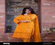 female model posing outdoors wearing orange indian pakistani asian traditional salwar kameez 2pgm592.jpg from pakistani suit salwar sexian collage xxx police se