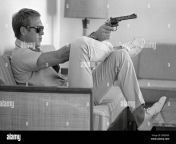 profile view of american actor steve mcqueen 1930 1980 sitting on a sofa in his home in palm springs california sunglasses over his eyes as he aims a handgun steve mcqueen widely considered one of the coolest and most charismatic actors of the 1960s and 1970s wears a white shirt and blue jeans steve mcqueen looks focused and determined with a slight twinkle in his eye and a firm grip around his gun the background is indistinct and out of focus creating a sense of isolation for the sitter the overall mood of the image is one of toughness confidence and a sense of danger 2re69g5.jpg from vcd blri lana xxx video sinhala sex m actress nayanthra sex