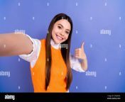 closeup selfie of positive funny schoolgirl blogger show thumb up like rate feedback wear orange vest isolated on purple color background 2rgjwxa.jpg from scholl gril selfi shows