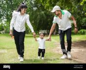 happy young indian parents both holding hands of their daughter walking in the park or garden 2tb6djg.jpg from desi indian couples funtime