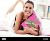 young woman unpacking a surprise present in bed mf0e8h.jpg from sleep surprise