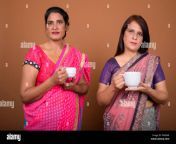 two mature indian women holding coffee or tea cup pxme6r.jpg from hot saree tea