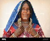 elderly indian lambadi woman banjara indian gypsy from karnataka poses in her traditional outfit for the camera and shows her silver jewelry t53wx6.jpg from indian lambadi