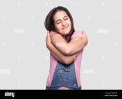 portrait of happy satisfied beautiful brunette young girl in casual pink t shirt and blue denim overalls standing hugging herself and enjoying indoo w8rh3y.jpg from desi indian playing herself and getting naked