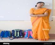 portrait of a teacher standing beside schoolbags in the classroom atnp4y.jpg from disi teacher