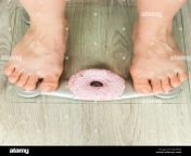 diet concept close up of womans feet on weighing scale with donut jxkfmg.jpg from woman toe food